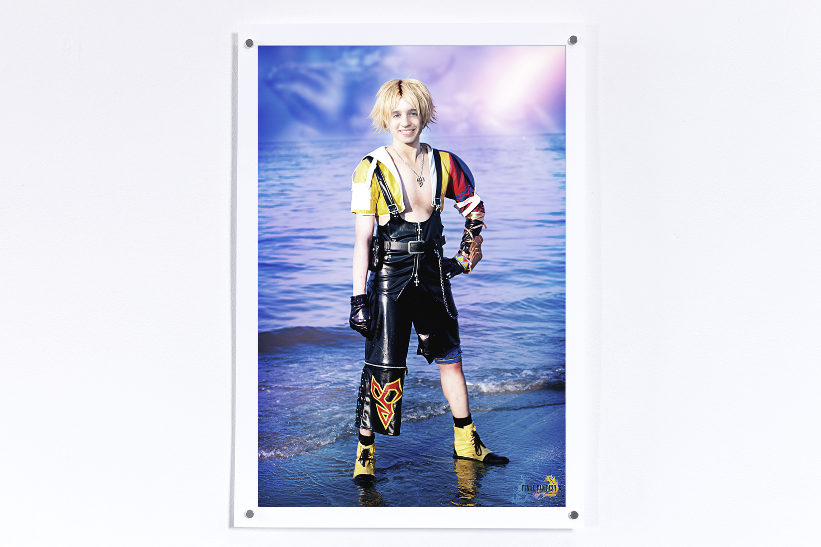 Print hung on a white wall of Tidus from Final Fantasy 10 on a beach with Jesse's face superimposed on the character